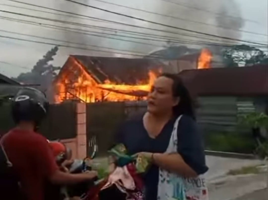 Warga tampak panik menyelamatkan barang berharga mereka saat kebakaran bangunan di Jalan Sukabumi Barat, Kecamatan Baamang, Senin (9/2/2026)