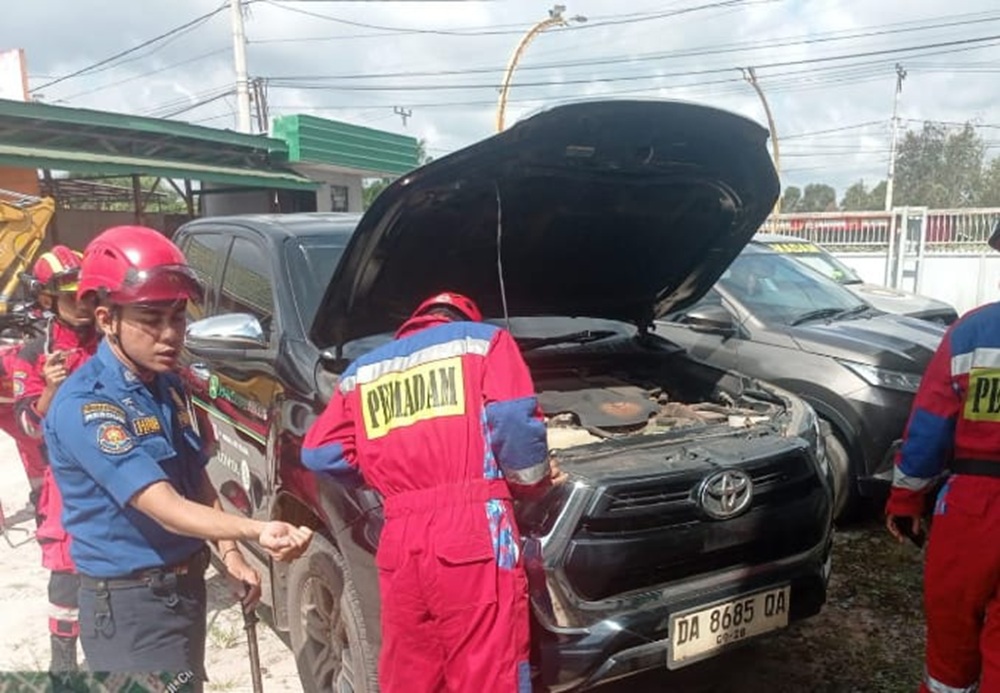 Petugas Disdamkarmat Kotim saat mengevakuasi ular yang masuk ke kap mobil warga di Jalan Tjilik Riwut Kilometer 4, Senin pagi (9/2/2026).