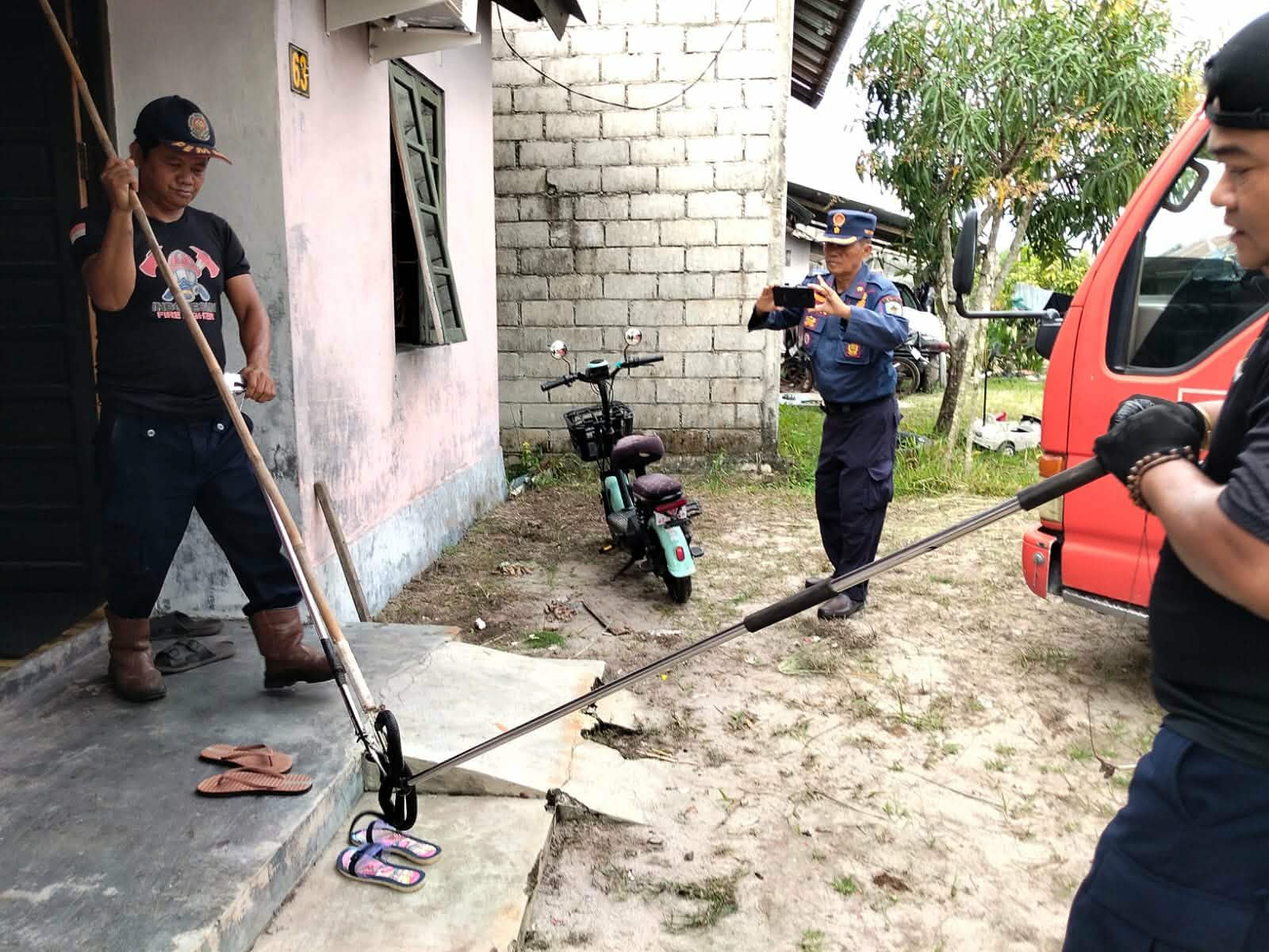 Tim Rescue Dinas Pemadam Kebakaran (Damkar) Kota Palangka Raya mengevakuasi seekor ular kobra hitam yang bersembunyi di lubang kloset rumah warga, Jalan Karanggan II.
