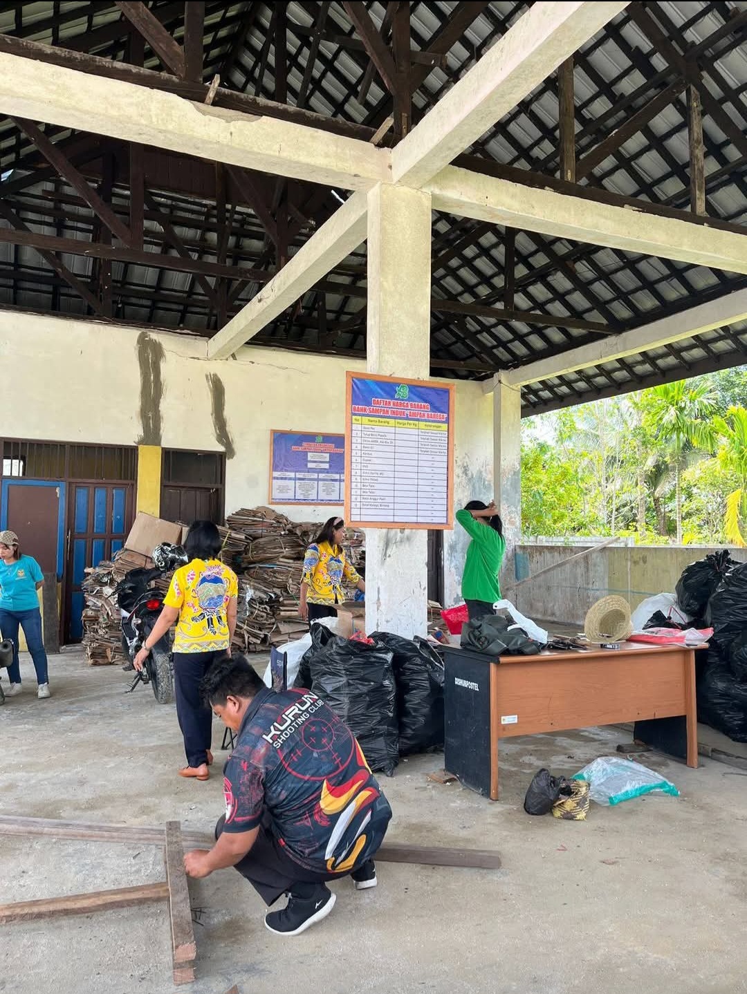 Pegawai DLHKP Gunung Mas mengumpulkan sampah anorganik di bank sampah induk Ampah Barega, belum lama ini.