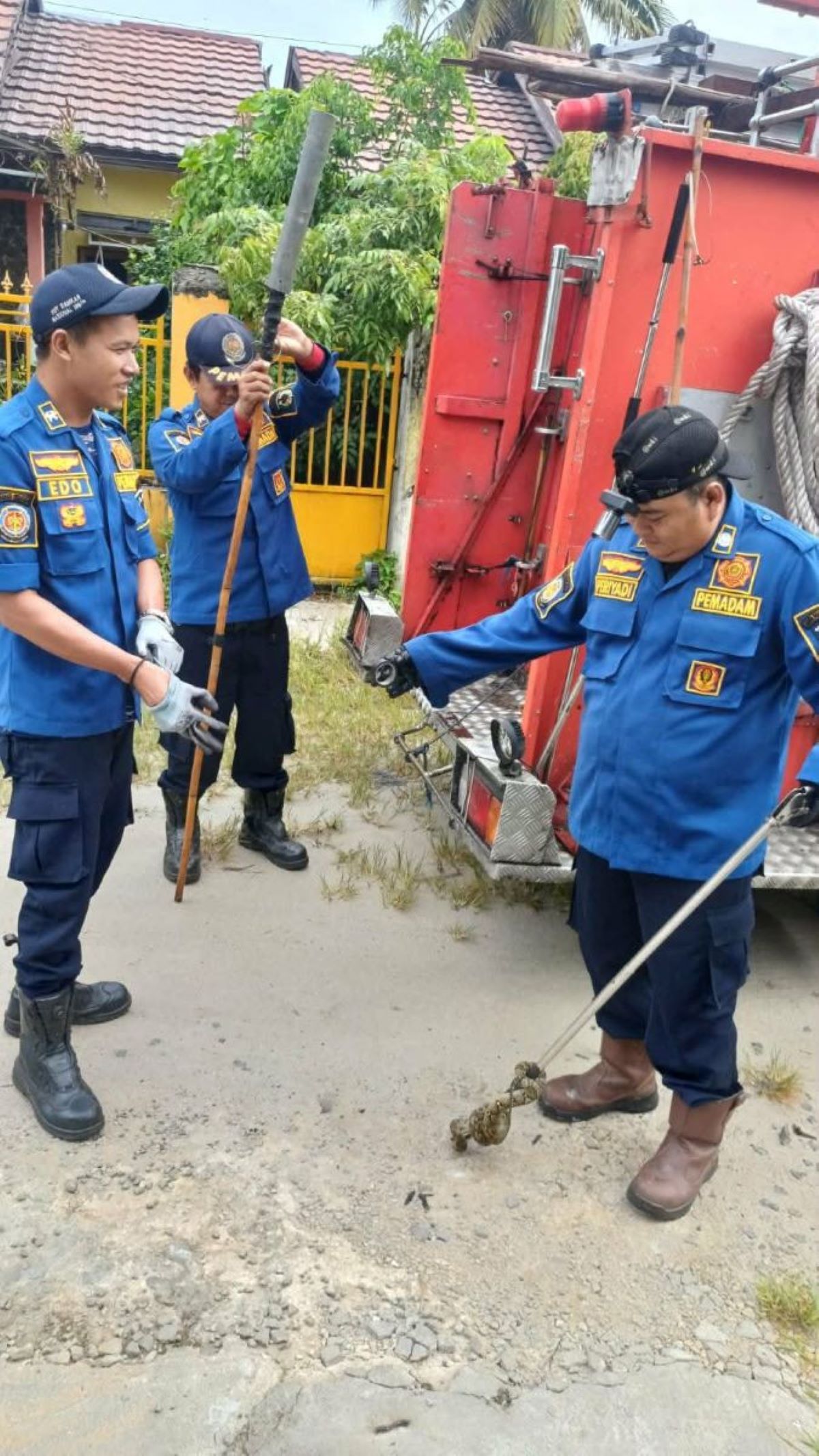 PENANGANAN : Petugas mengevakuasi seekor ular piton ganas yang masuk ke rumah warga di Jalan Puteri Junjung Buih III, Kota Palangka Raya. FOTO: DODI/RADAR SAMPIT