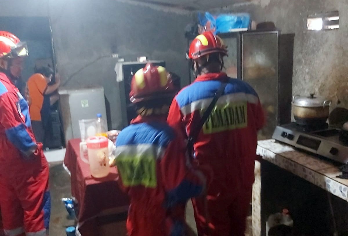 Pemilik rumah di Jalan Sawit Raya Sampit menunjukkan lokasi keberadaan ular kepada petugas Disdamkarmat Kotim. (Disdamkarmat Kotim)