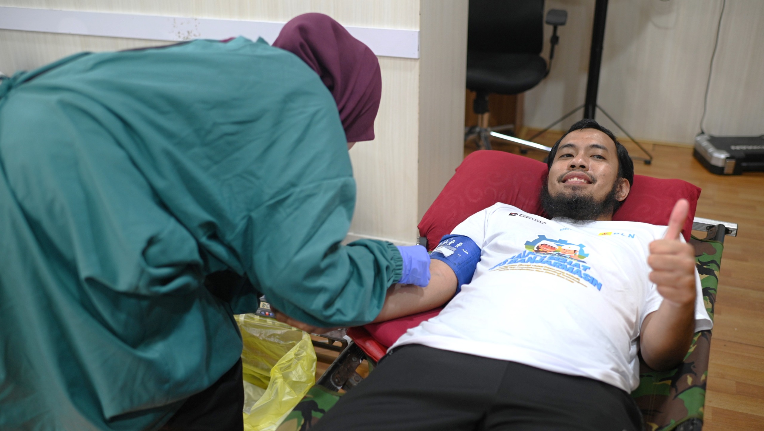 Petugas medis dari Palang Merah Indonesia (PMI) melakukan pengambilan darah salah satu pegawai PLN di UP3 Banjarmasin.