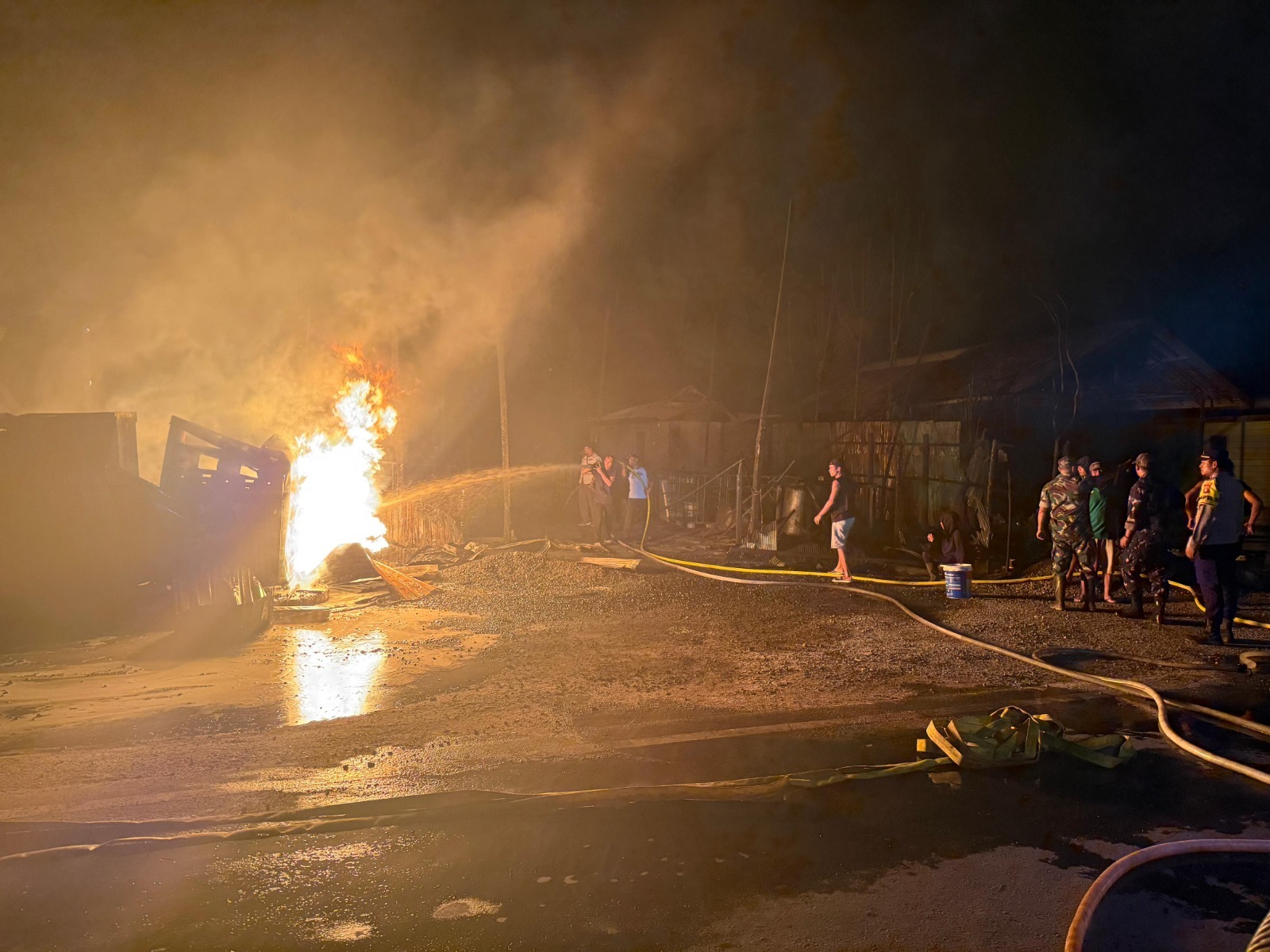 Sejumlah pihak terkait dibantu warga sekitar ketika berupaya memadamkan api yang menghanguskan ruko, di Jalan Lintas Kuala Kurun-Palangka Raya, Rab