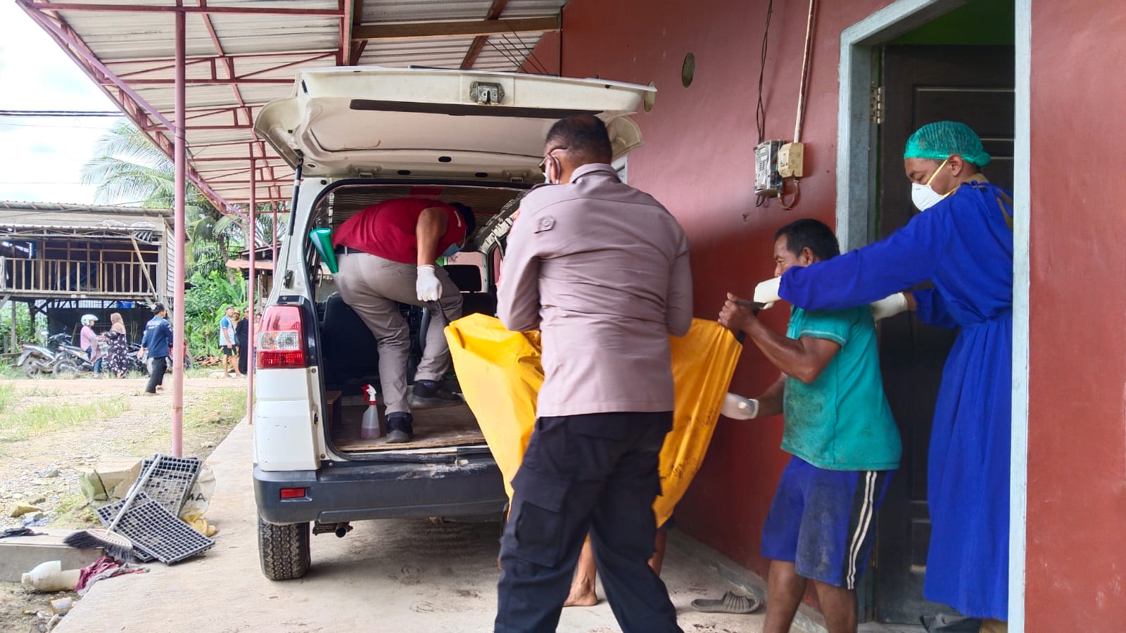 EVAKUASI: Petugas kesehatan dan aparat Polsek Pangkalan Banteng saat menggotong jenazah dari dalam kontrakan menuju ambulans. (Polres Kobar)
