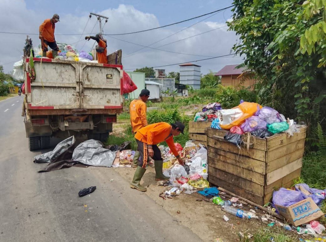 Petugas kebersihan dari DLHKP ketika mengangkut sampah dari tempat pembuangan ke truk pengangkut, pekan lalu. 