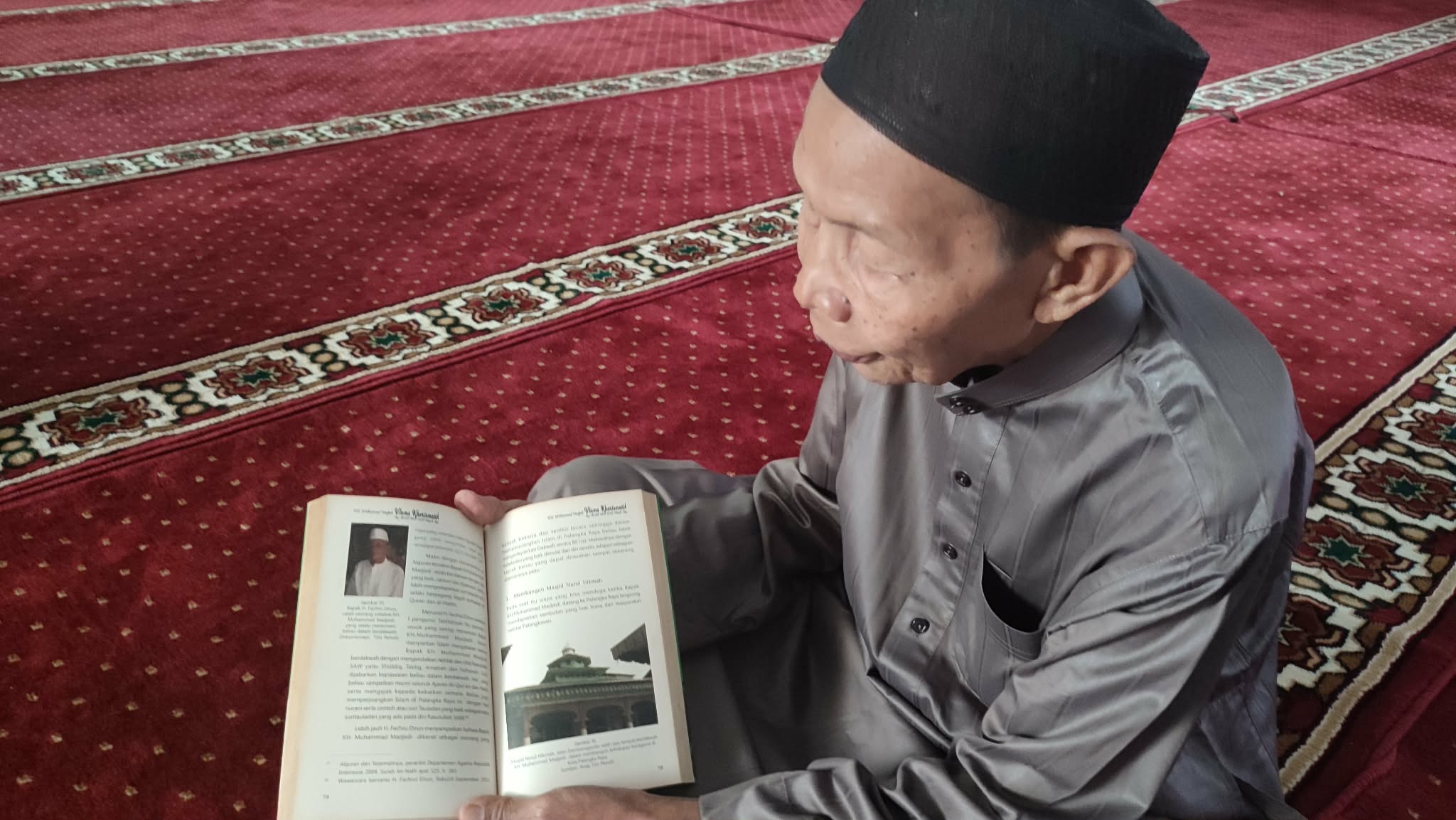 Marbot Masjid Nurul Hikmah Abdul Satar saat dibincangi Radar Sampit,sambil menunjukan buku sejarah terkait pendirian masjid bersejarah itu.