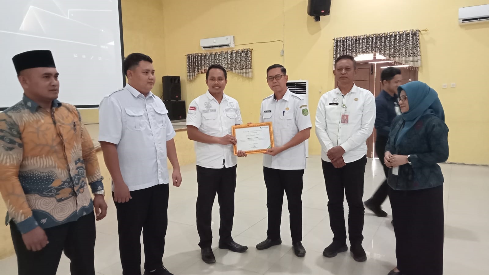 Asisten Pemerintahan dan Kesra Setda Sukamara Yofi Yudistira menyerahkan penghargaan bagi desa.
