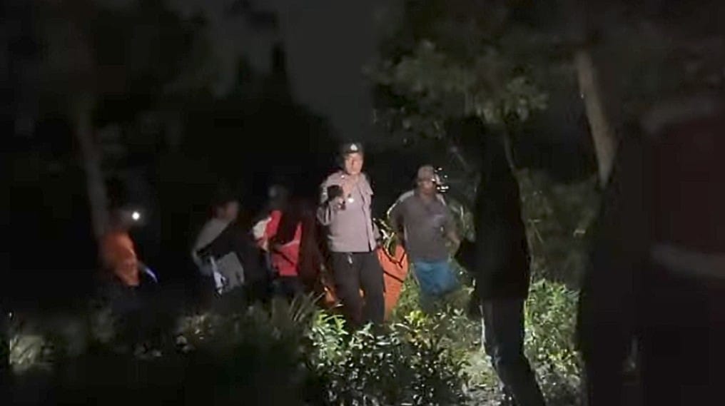 Petugas terpaksa harus berjalan kaki saat evakuasi jasad korban meninggal dengan cara tak wajar di Kawasan Sawit Raya Dalam, Sabtu malam (28/2/2026). (warga/radar sampit)