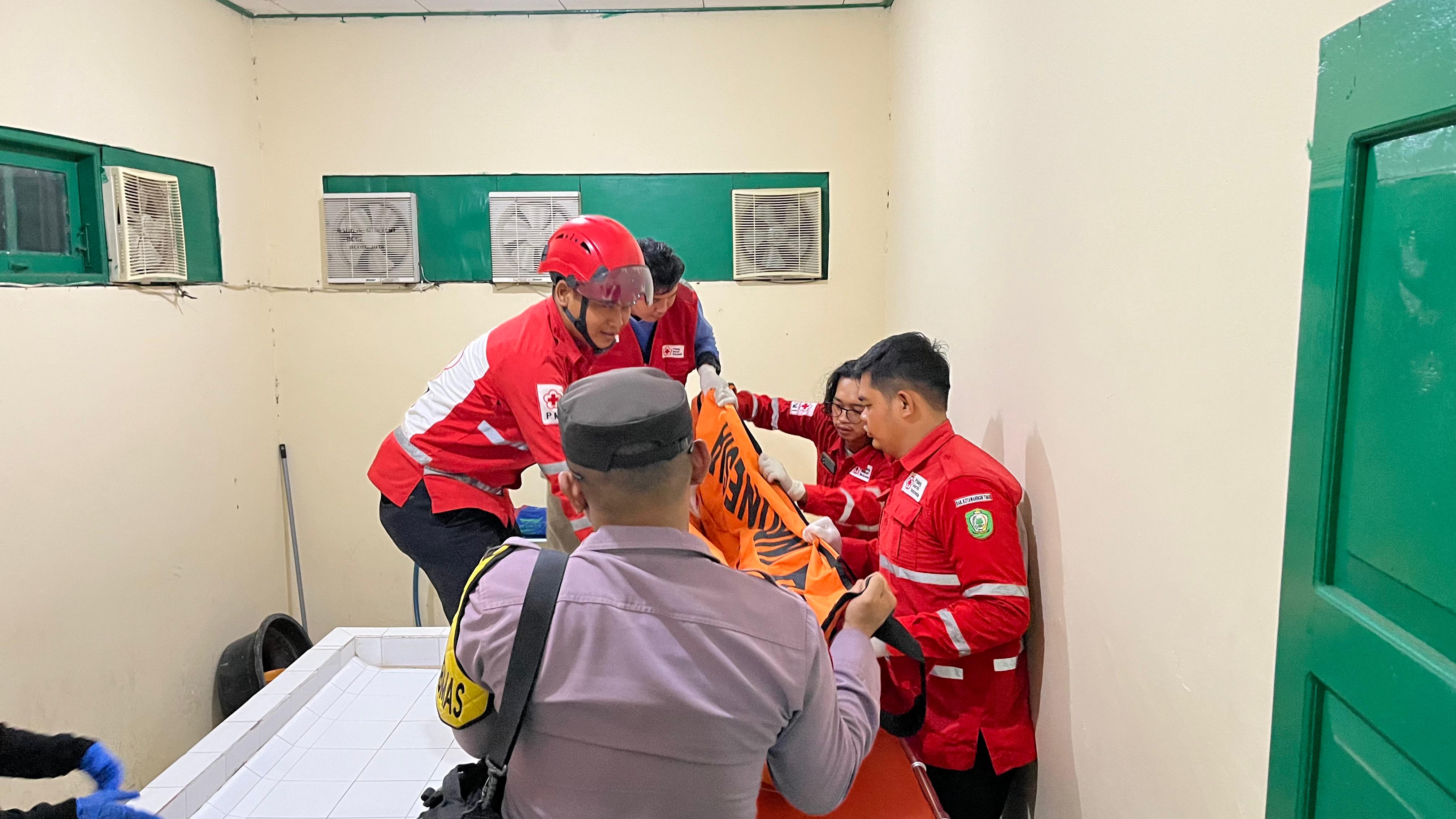 TEWAS TERGANTUNG: Petugas gabungan saat mengevakuasi sesosok mayat  laki-laki ke RSUD Dr Murjani, Sabtu (28/2) malam.PMI/RADAR SAMPIT