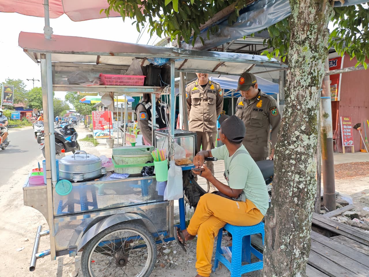 TEGURAN : Sejumlah anggota Satpol PP Kotim memberikan teguran kepada pedagang yang berjualan makanan secara vulgar di siang hari saat momentum bulan suci Ramadan, Sabtu (28/2).&nbsp;WIDYA FOR RADAR SAMPIT