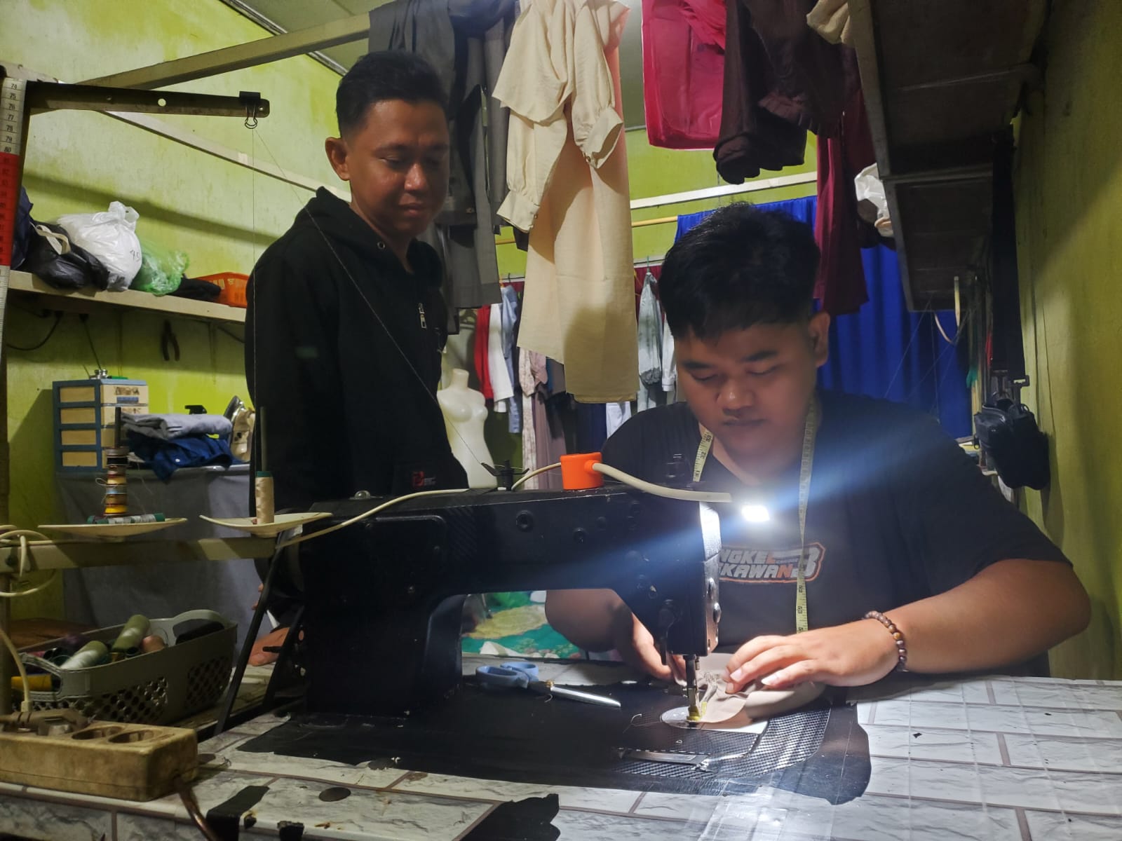Penjahit di salah satu kios di Komplkes Pasar Berdikari Sampit bekerja hingga dini hari untuk memenuhi pesanan pelanggan untuk keperluan lebaran. (Usay Nor Rahmad/Radar Sampit)