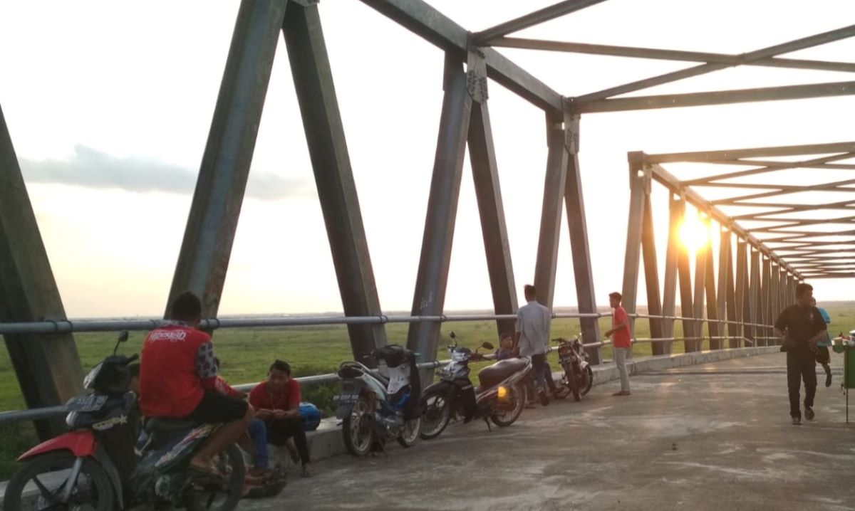 NGABUBURIT: Sejumlah warga saat bersantai di jembatan Jelai yang masih belum fungsional. 
