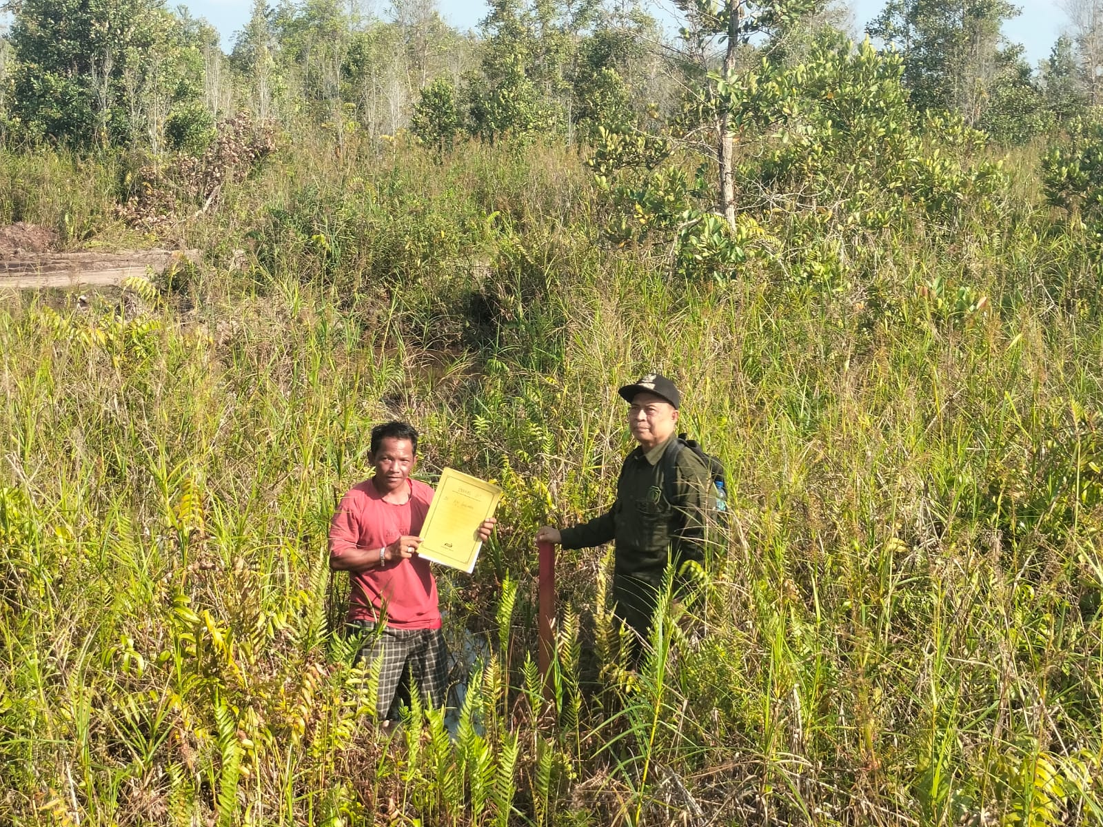 Kepala Desa Tewang Kedamba Sabto Marjono dan Aji Susamho saat memasang patok dan menentukan titik koordinaat. (Yuswanto RS/Radar Sampit)