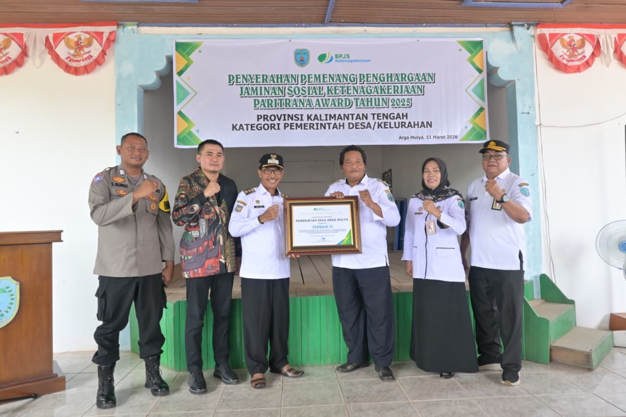 Wakil Bupati Lamandau menyerahan penghargaan Paritrana Award kepada Kepala Desa Arga Mulya.  