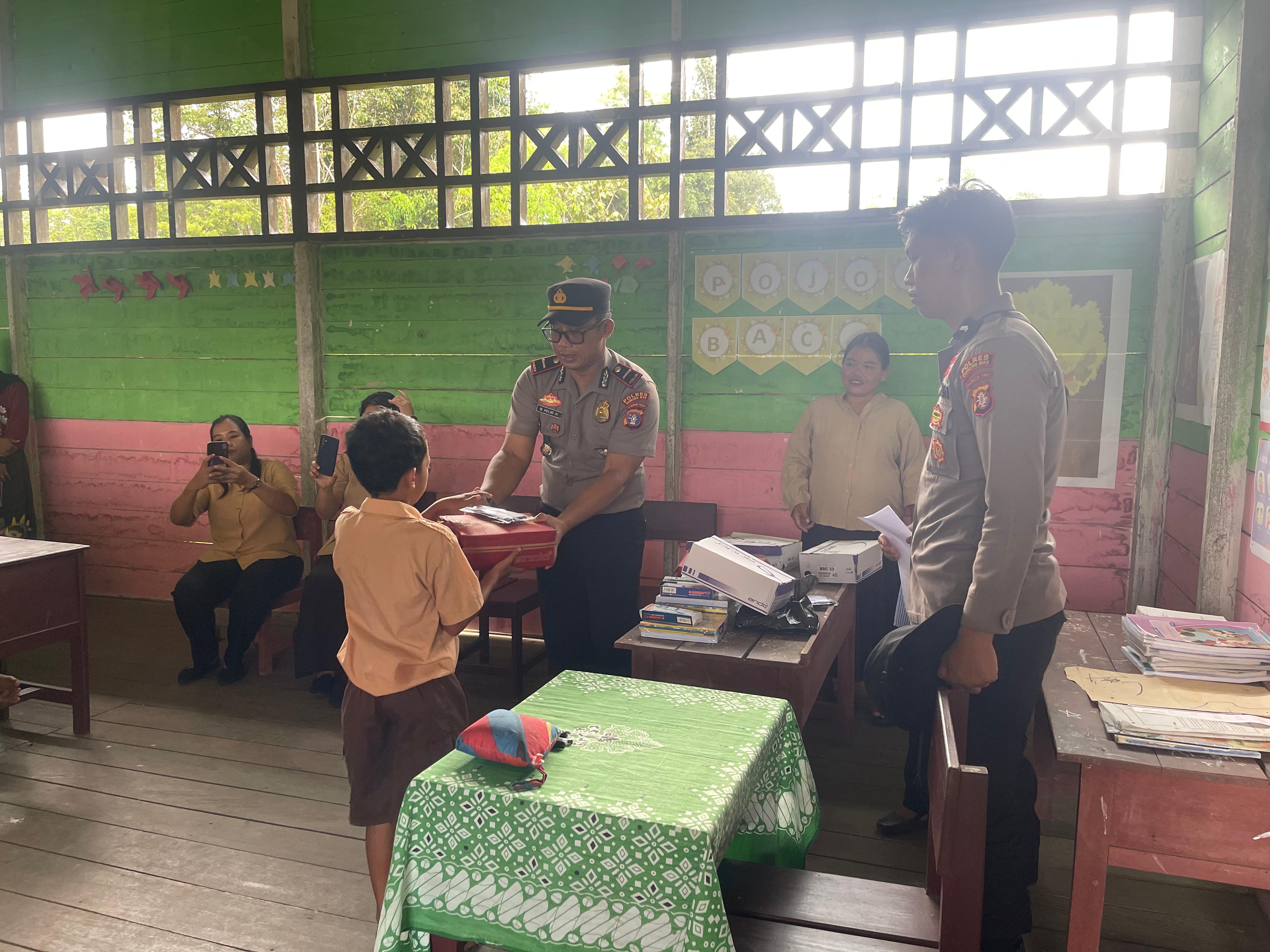 BERSAMA: Kapolsek Rungan Ipda Muhamad Helmi Hakim dan personel polsek berfoto ketika bersama dengan kepala sekolah, guru dan murid SDN Luwuk Kantor, Sabtu (14/3).&nbsp;POLSEK RUNGAN FOR RADAR SAMPIT