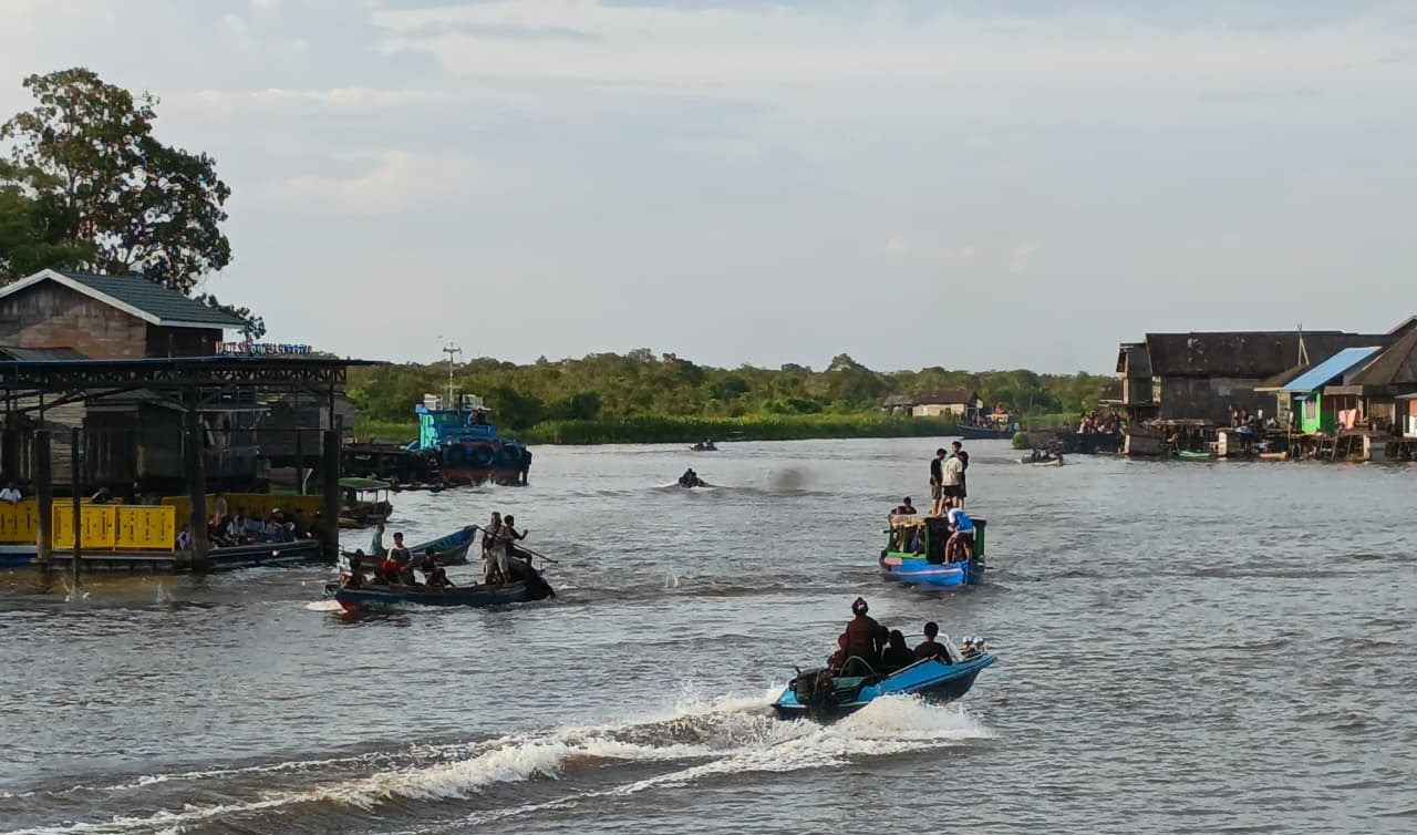 Sejumlah warga menggunakan perahu sampai speedboat berseliweran di tengah sungai.  