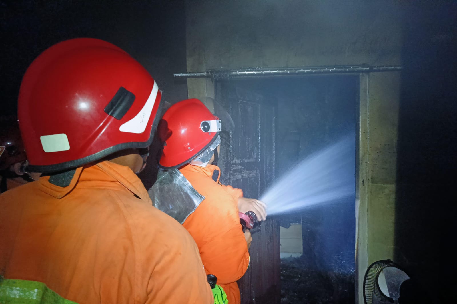 Petugas memadamkan api yang membakar sebuah kamar di salah satu rumah di perumahan Mandiri Resodence, Jalan Walter Condrat, Kecamatan Baamang, Rabu malam (25/3/2026).