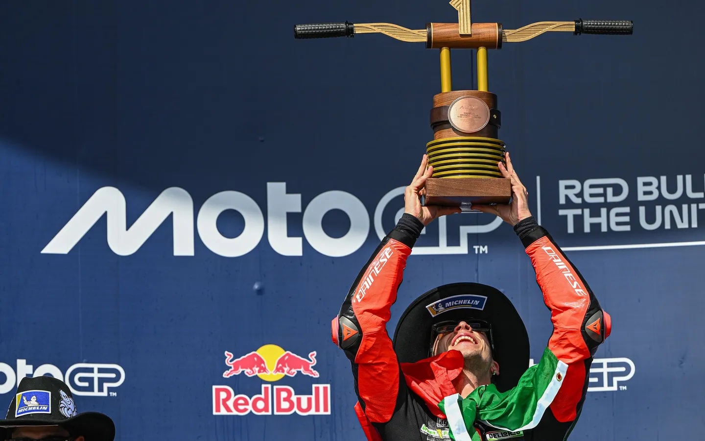 Marco Bezzecchi saat mengangkat trofo kemenangannya di MotoGP Amerika. (MotoGP.com)