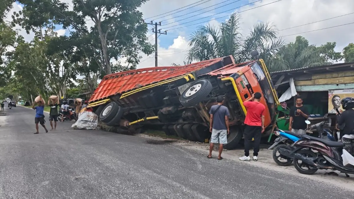 KECELAKAAN TUNGGAL: Truk fuso bermuatan pakan ternak amblas dan nyaris terguling di Jalan Ratu Mangku, Kelurahan Sidorejo, Kecamatan Arsel, Kabupaten Kobar, Jumat (10/4/2026). FOTO: DISHUB KOBAR/RADAR SAMPIT 