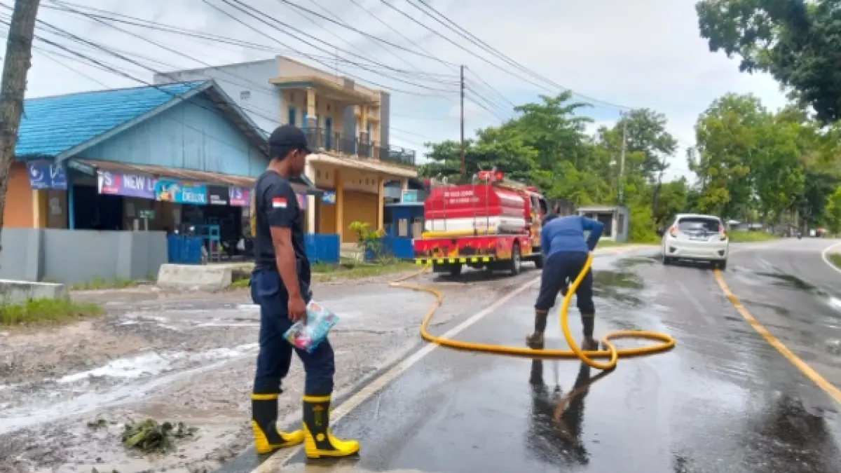 Personel Dinas Pemadam Kebakaran dan Penyelamatan Kabupaten Kotawaringin Barat melakukan penyemprotan tumpahan solar di Jalan Ahmad Yani kilometer 5, Kelurahan Baru, Selasa 13 April 2026. (DAMKAR KOBAR) 