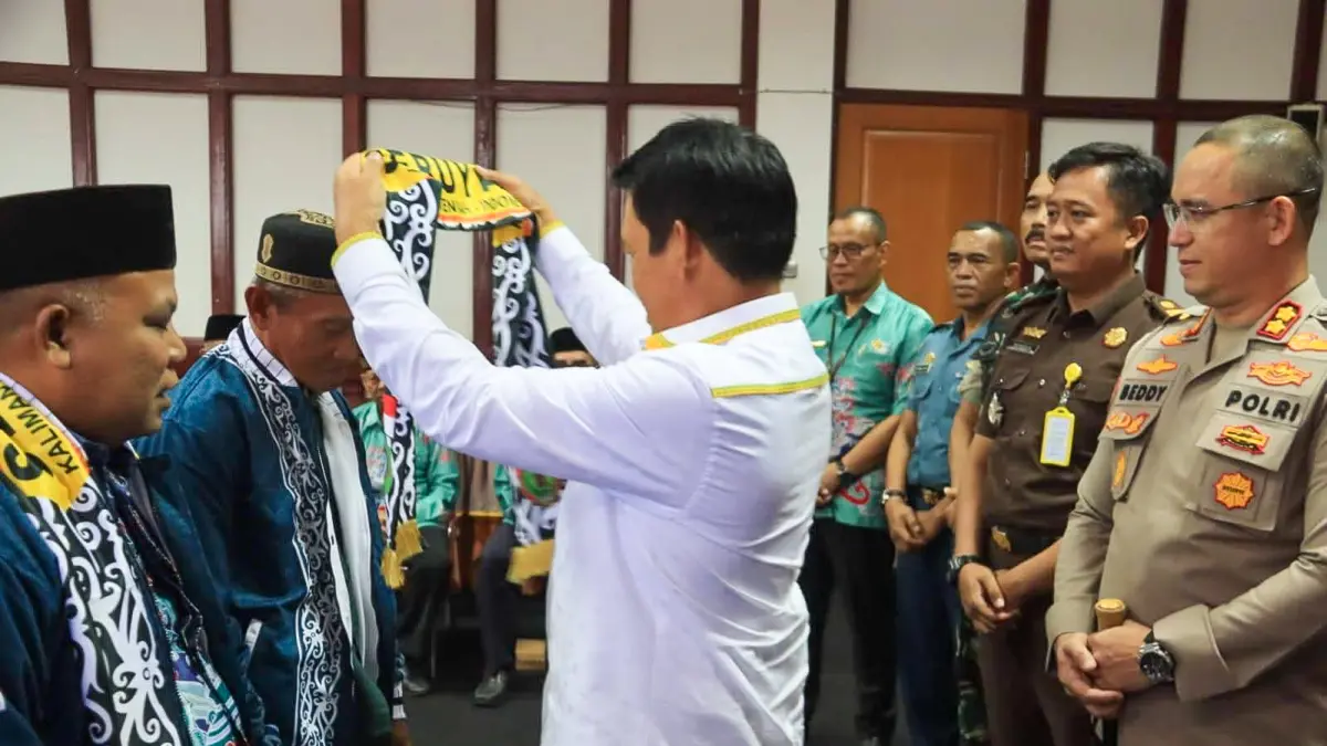 PELEPASAN: Bupati Seruyan Ahmad Selanorwanda memasangkan syal kepada jemaah calon haji dalam prosesi pelepasan di Aula Kantor Bupati Seruyan. Rabu (29/4/2026). FOTO: RIFANI/RADAR SAMPIT