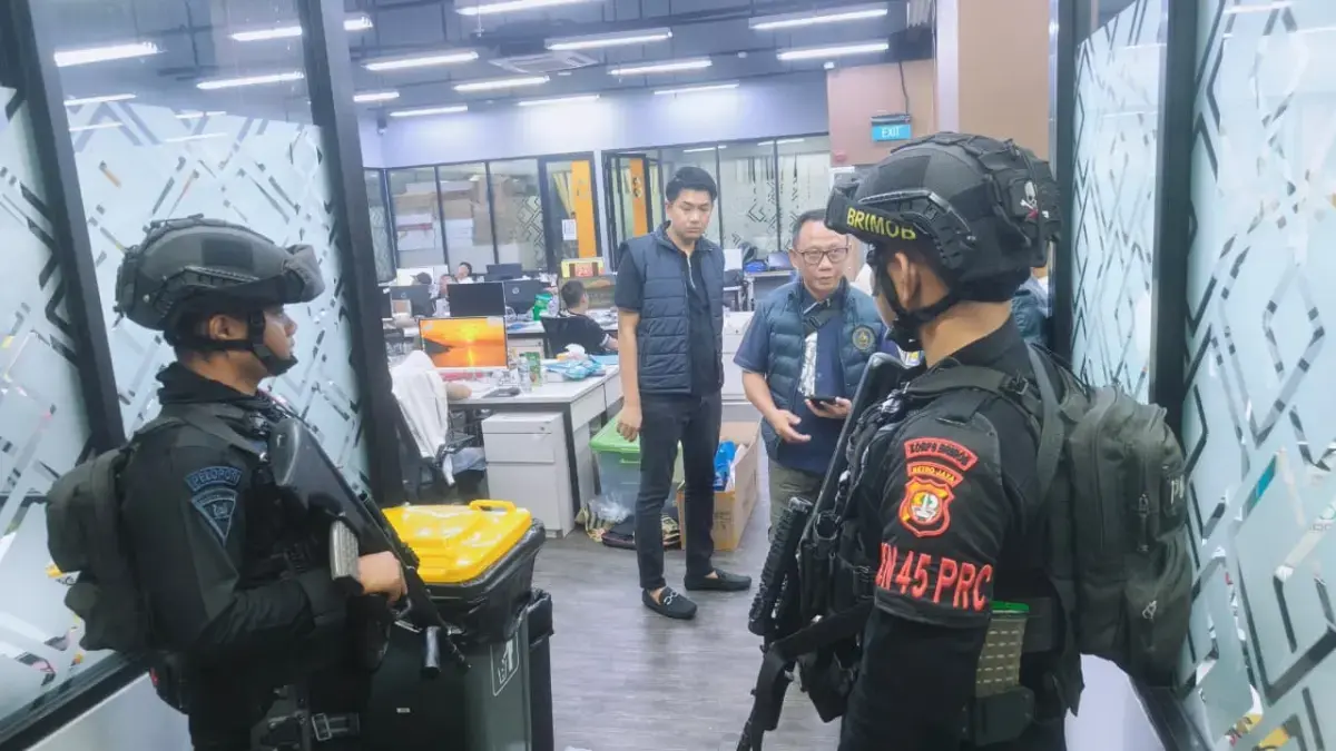 Personel Brimob dari Polda Metro Jaya mengamankan lokasi penindakan sindikat judul internasional di Kawasan Hayam Wuruk, Jakbar, pada Sabtu (9/5). (Polda Metro Jaya)