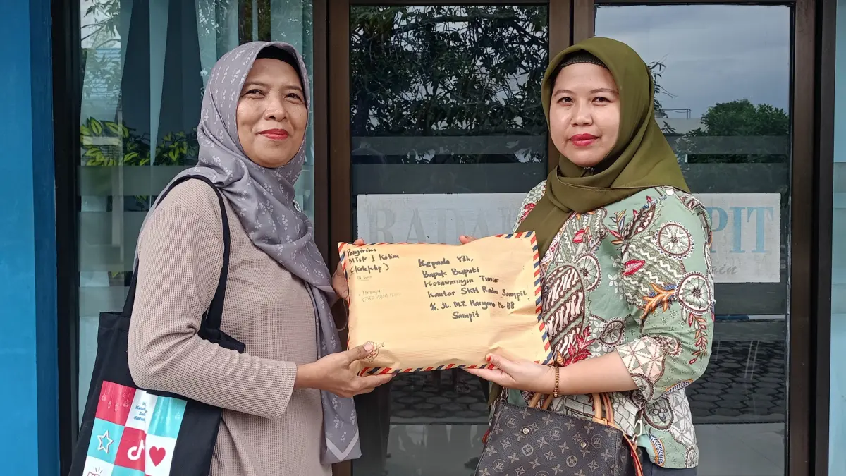 Guru Bahasa Indonsia MTsN 1 Kotawaringin Timur Hatmiyati SPd menyerahkan karya para pelajar secara kolektif kepada pantia lomba di Radar Sampit pada Jumat (8/5) sore. (Heru/radarsampit)