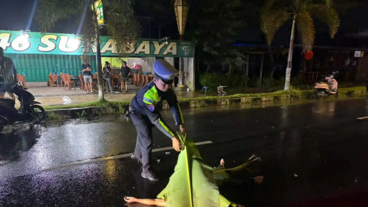Petugas kepolisian saat melakukan evakuasi terhadap korban lakatunggal inisial Ca (21) yang ditemukan tewas setelah dilindas sebuah mobil, yang kini dalam pencarian polisi.(istimewa/Satlantas Polresta)