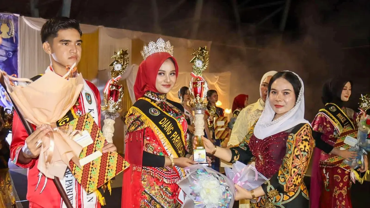 Ketua TP-PKK Kabupaten Seruyan Welduline Ahmad Selanorwanda menyerahkan piala kepada salah satu finalis Kucung Diang Pariwisata Kabupaten Seruyan Tahun 2026, Sabtu (9/5) malam. &nbsp;(rifani/radar sampit)