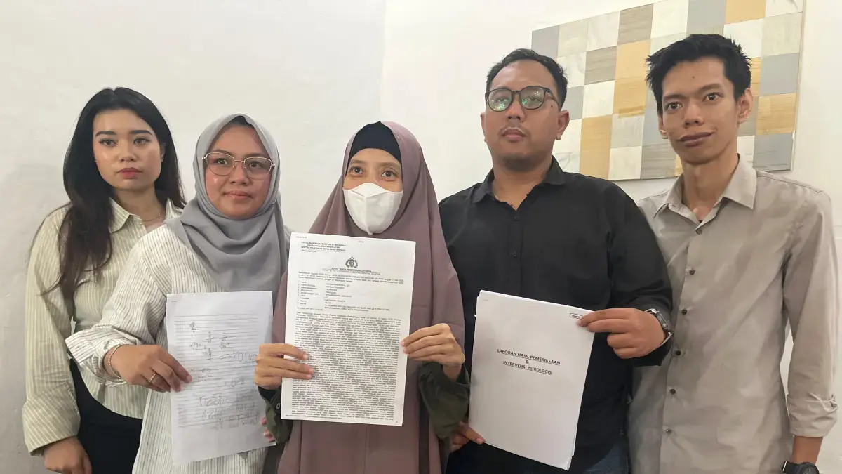 Didampingi kuasa hukumnya, istri Salehuddin menunjukkan laporan polisi. (Muhammad Oscar Fraby/Radar Banjarmasin)