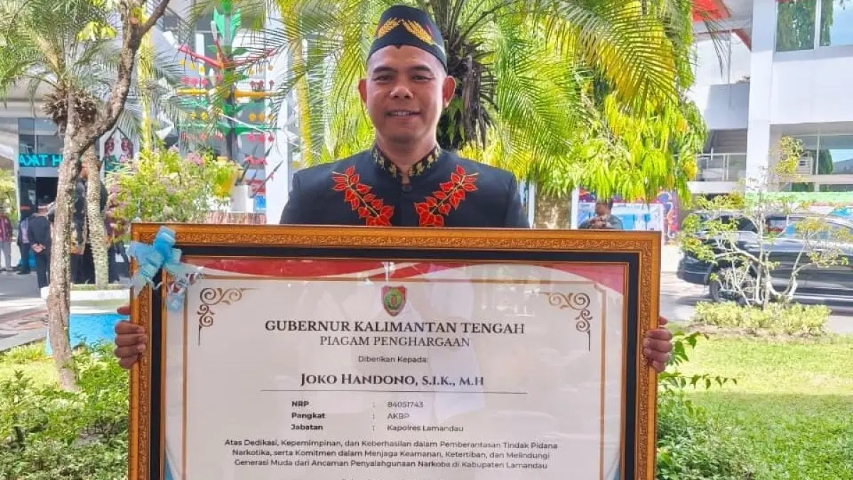 Kapolres Lamandau, AKBP Joko Handono, saat memegang penghargaan dari Gubernur Kalteng, Agustiar Sabran, di halaman kantor Gubernur Kalteng, di Palangkaraya, Sabtu (23/5). ( HUMAS POLRES)