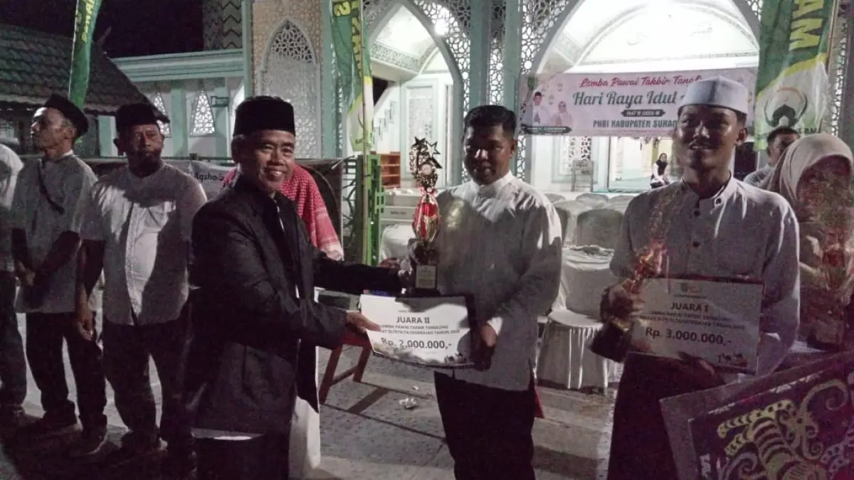 Ketua PHBI Sukamara, M Saleh saat menyerahkan tropi dan uang pembinaan kepada juara pawai takbir.&nbsp; (FAUZIANNUR/RADAR SAMPIT) &nbsp;