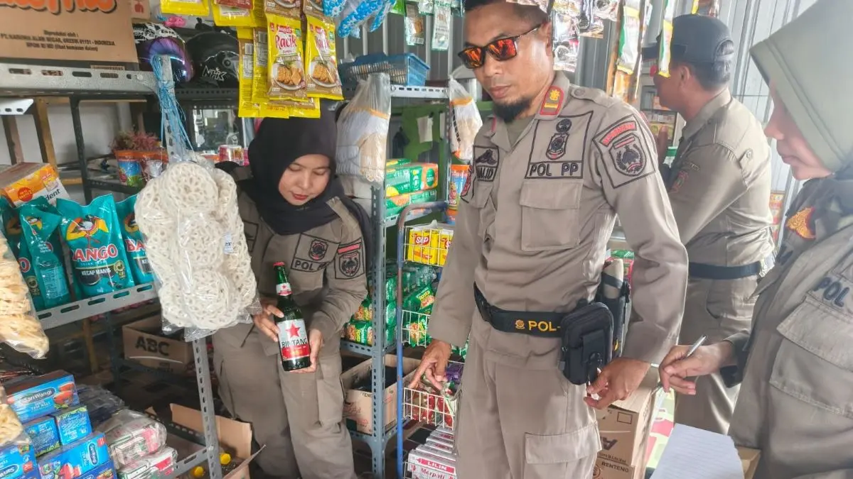 RAZIA MIRAS: Satpol PP Kobar mengamankan puluhan botol minuman keras dari sebuah warung sembako di Jalan Ahmad Yani, Desa Purbasari, Kecamatan Pangkalan Lada, Selasa (2/6/2026). FOTO: IST/RADAR SAMPIT