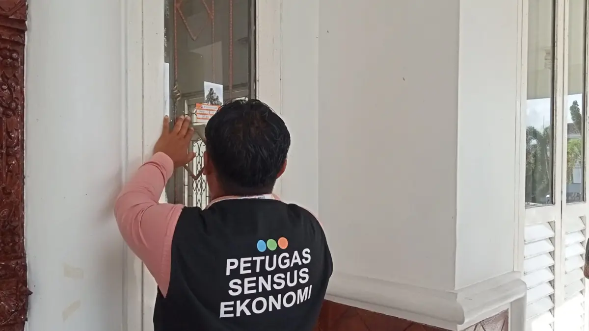 Petugas Sensus Ekonomi 2026 menempelkan stiker sensus pada salah satu rumah saat melaksanakan pendataan. (FAUZIANNUR/RADAR SAMPIT)&nbsp; 
