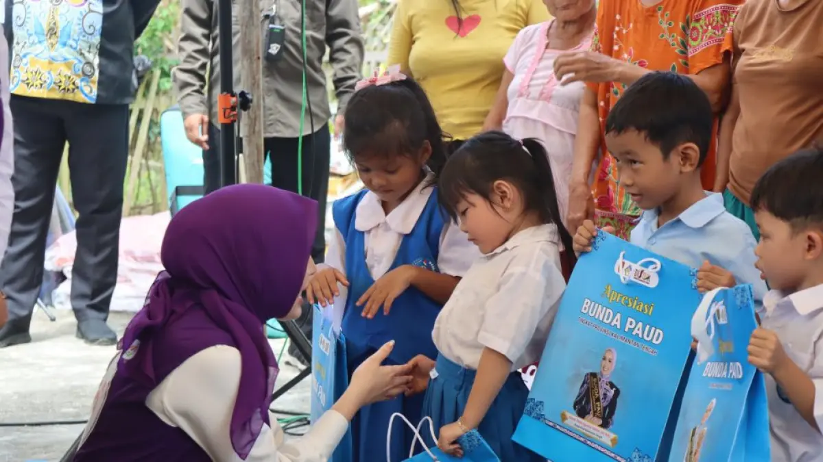 Ketua TP-PKK Provinsi Kaltenh Aisyah Thisia Agustiar Sabran didampingi Ketua TP-PKK Kabupaten Gumas Mimie Mariatie Jaya Samaya Monong, ketika menyerahkan bantuan buku kepada murid TK, Senin (23/6). (TP-PKK GUNUNG MAS FOR RADAR SAMPIT)&nbsp;