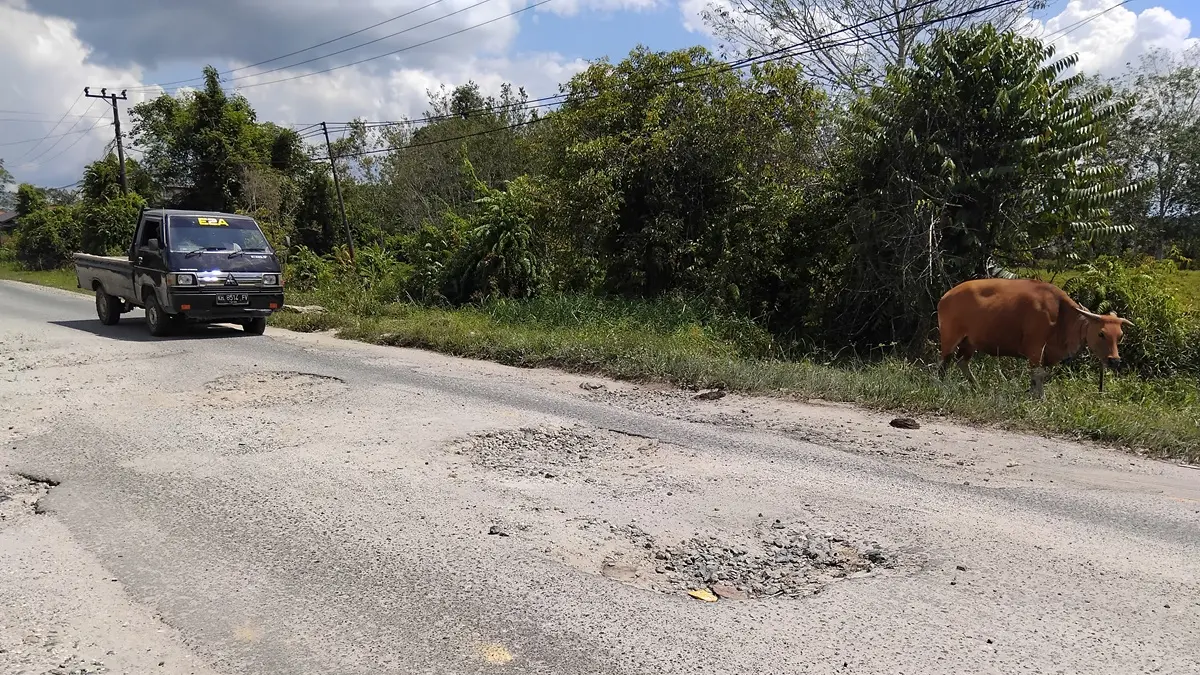 BERLUBANG : Kondisi ruas Jalan Jenderal Sudirman yang berlubang, di Kota Kuala Kurun, Kamis (25/6). (ARHAM SAID/RADAR SAMPIT)