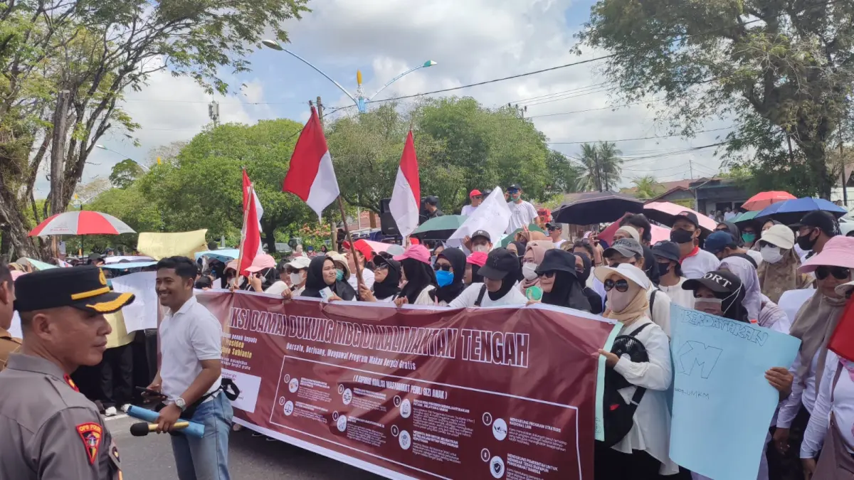 Puluhan warga menggelar aksi damai di depan Kantor Gubernur Kalimantan Tengah (Kalteng), Selasa (30/6/2026). Aksi ini sebagai bentuk dukungan terhadap Program Makan Bergizi Gratis (MBG)