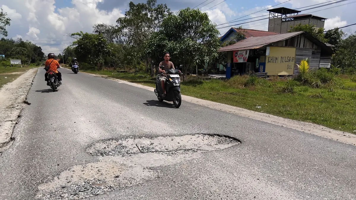 BERLUBANG: Kondisi Jalan Jenderal Sudirman, Kota Kuala Kurun, yang rusak, Selasa (30/6). (ARHAM SAID/RADAR SAMPIT)&nbsp;