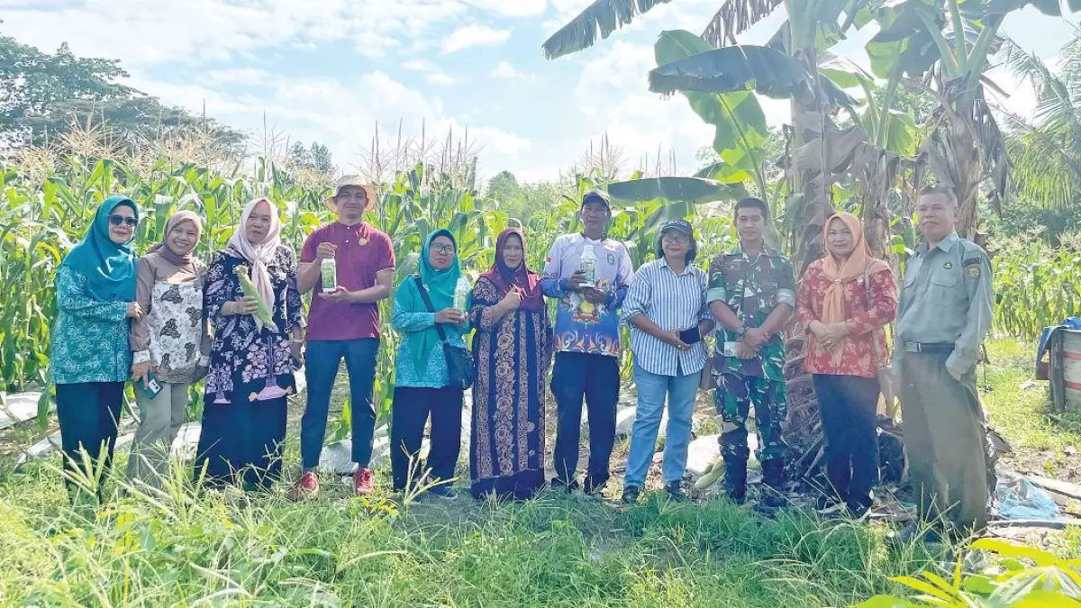 PANEN JAGUNG : Para petani foto bersama dengan petugas penyuluh pertanian dan Ketua Dharma Wanita Persatuan Kecamatan MB Ketapang Ny Nurainah Irpansyah didampingi Sekretaris Lurah Ketapang Yulia Rahma usai panen jagung di Jalan Teratai V Sampit, Kamis (2/7/2027). FOTO: IST/RADAR SAMPIT