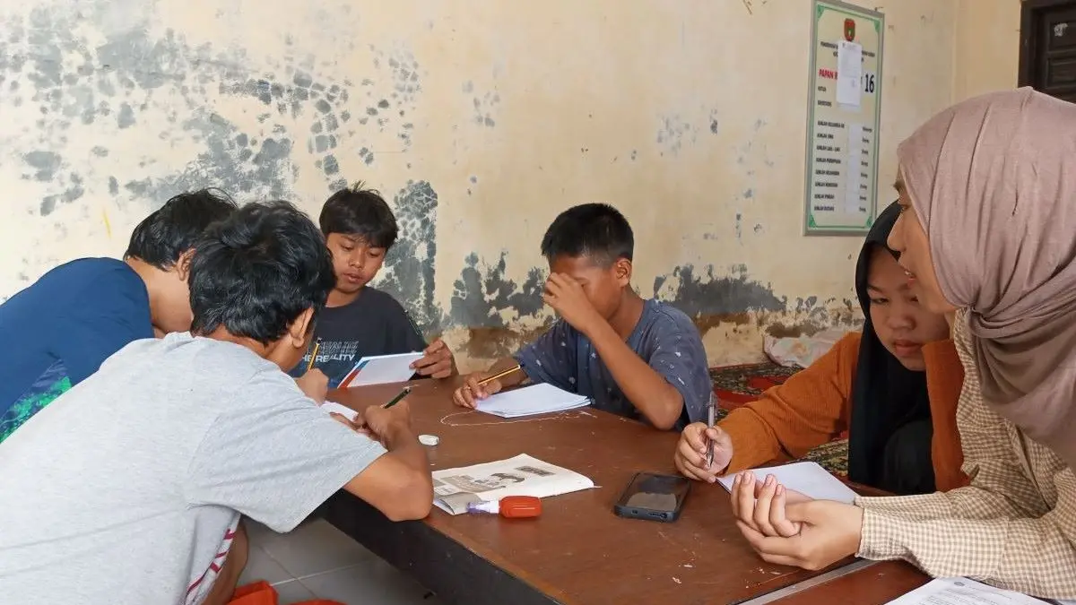 BELAJAR: Mia Cisadani sang founder Komunitas Insan Kreatif Gemilang memberi pelajaran baca tulis anak-anak di Kobar. FOTO: IST/RADAR SAMPIT