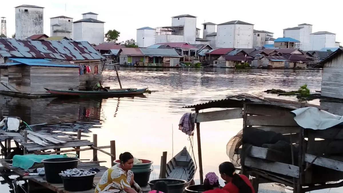 Para perempuan di Desa Batilap, Kabupaten Barito Selatan, Kalimantan Tengah menggarami ikan hasil tangkapan. Mayoritas penduduk desa ini berprofesi sebagai nelayan dengan penghasilan bersih rata-rata Rp 1.000.000 per bulan per keluarga dari hasil menangkap ikan. (Foto: Andriani SJ Kusni/2025) 