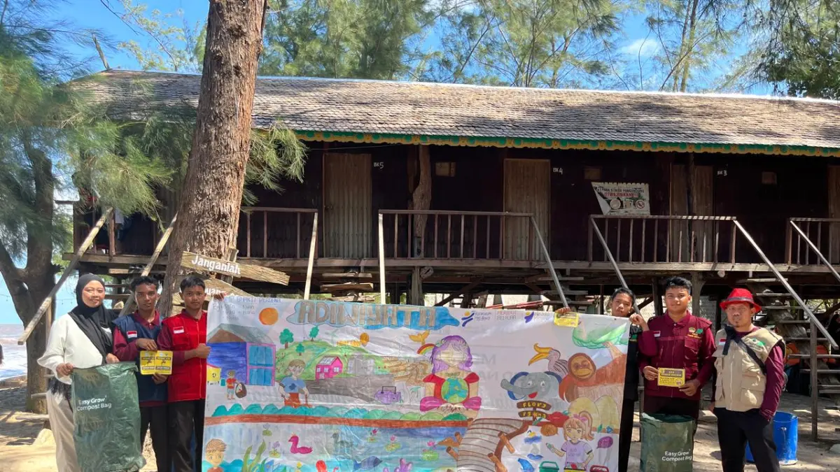 PEGIAT LINGKUNGAN: Kader Adiwiyata SMP Bhakti Perdana bersama guru pendamping membentangkan spanduk sebagai bagian dari mengkampanyekan pelestarian lingkungan di Pantai Ujung Pandaran, Minggu (21/7/2026). (SMP BHAKTI PERDANA FOR RADAR SAMPIT)