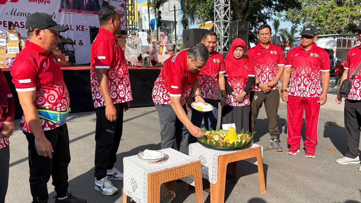 POTONG TUMPENG: Pemotongan nasi tumpeng oleh Pj Sekda Kotim, pada peringatan Hari Koperasi Nasional ke-79 dan Hari UMKM Nasional 2026 di Taman Kota Sampit, Minggu (12/7/2026). FOTO: YUNI/RADAR SAMPIT 