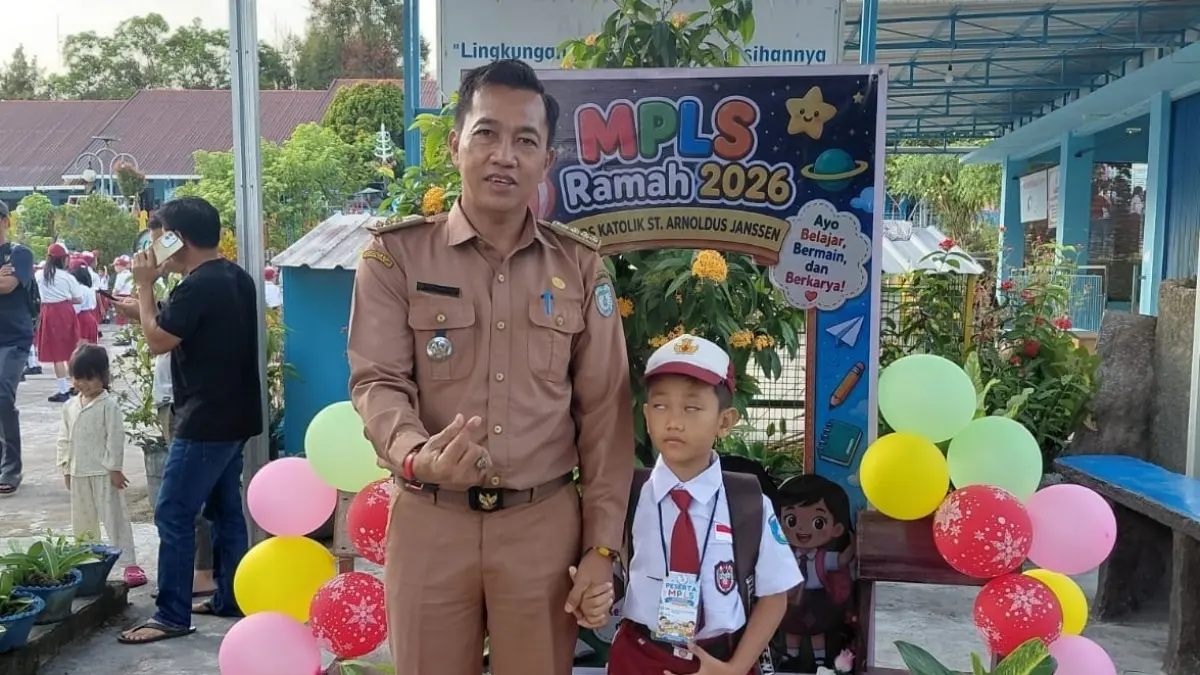 Ayah mengantarkan anaknya pada hari pertama masuk sekolah Tahun Ajaran 2026/2027, Senin (13/7).&nbsp;(RIA/RADAR SAMPIT) 