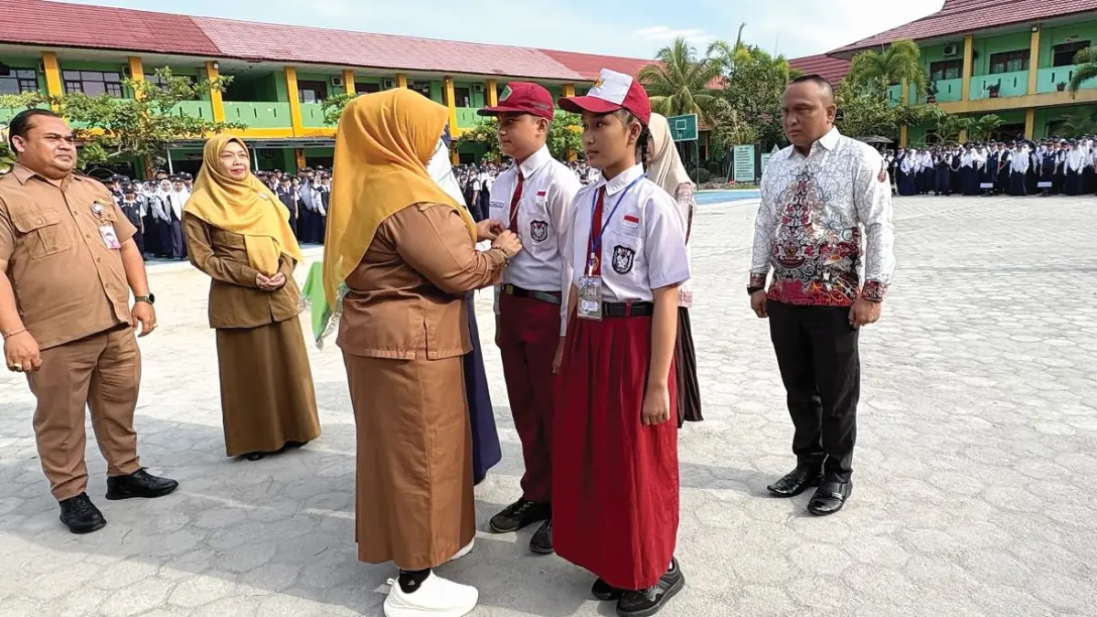 TAHUN AJARAN BARU: Wabup Kotim Irawati menyematkan tanda peserta kepada siswa-siswi baru SMPN 1 Sampit saat pembukaan MPLS, Senin (13/7/2026). FOTO: YUNI/RADAR SAMPIT