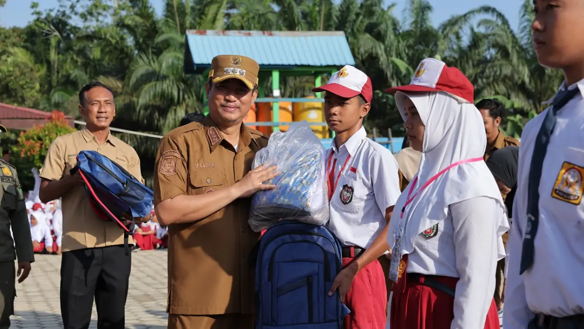 Bupati Sukamara Masduki&nbsp; menyerahkan seragam dan tas gratis kepada siswa baru. (FAUZIANNUR/RADAR SAMPIT)&nbsp;
