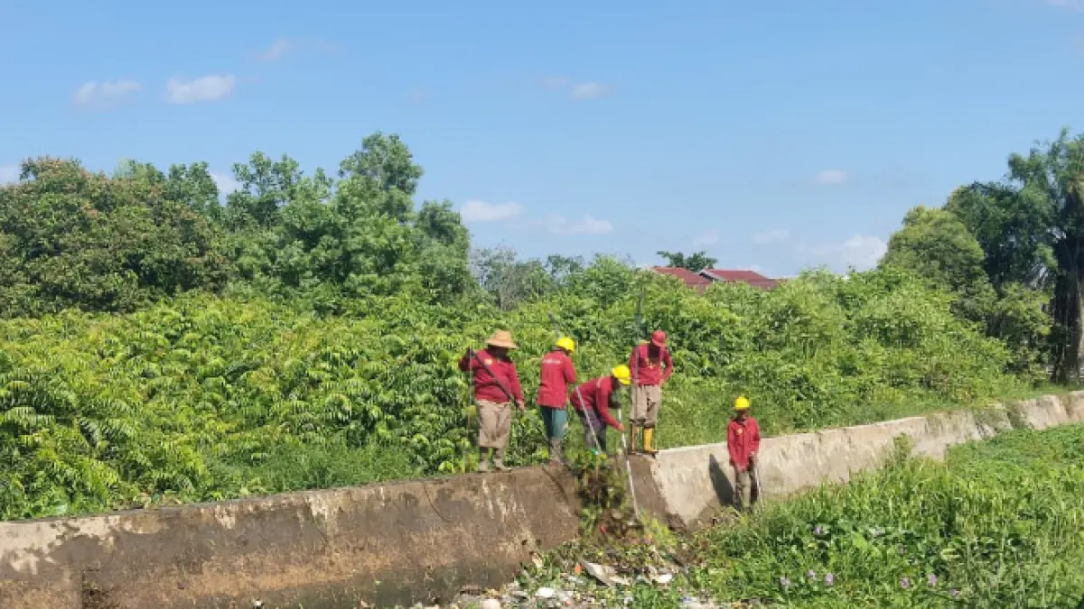 Satgas SDA Dinas PUPR Kobar membersihkan saluran induk di Jalan PKGB Gang Anugerah 1, Kecamatan Arut Selatan, Selasa (14/7). (SYAMSUDIN/RADAR SAMPIT)&nbsp;