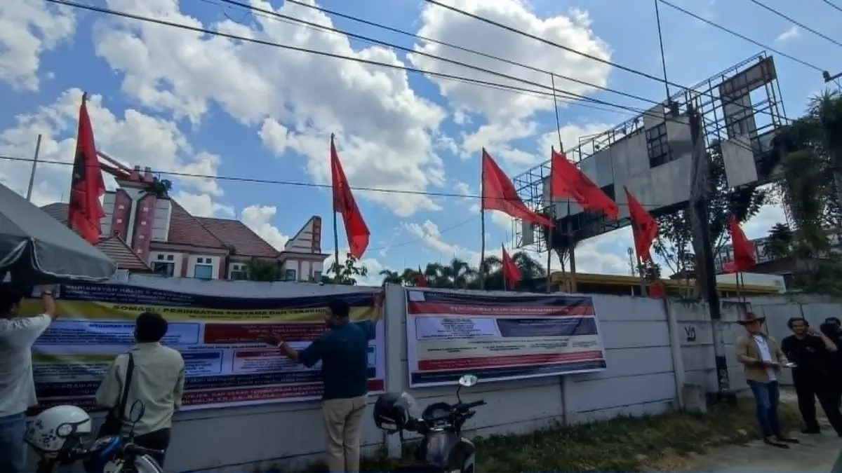 Pihak kuasa hukum R Atu Narang saat memasang spanduk peringatan agar mengosongkan lokasi eks kantor PDI Perjuangan Kalteng itu, Sabtu (18/7).(dodi/radarsampit)