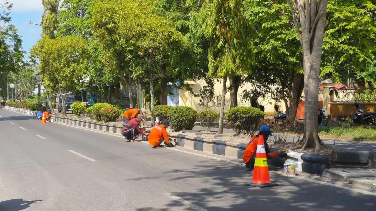Sejumlah pekerja saat mengecat median jalan yang berada di Jalan HM Arsyad Sampit.  (Akbar/Radar Sampit)